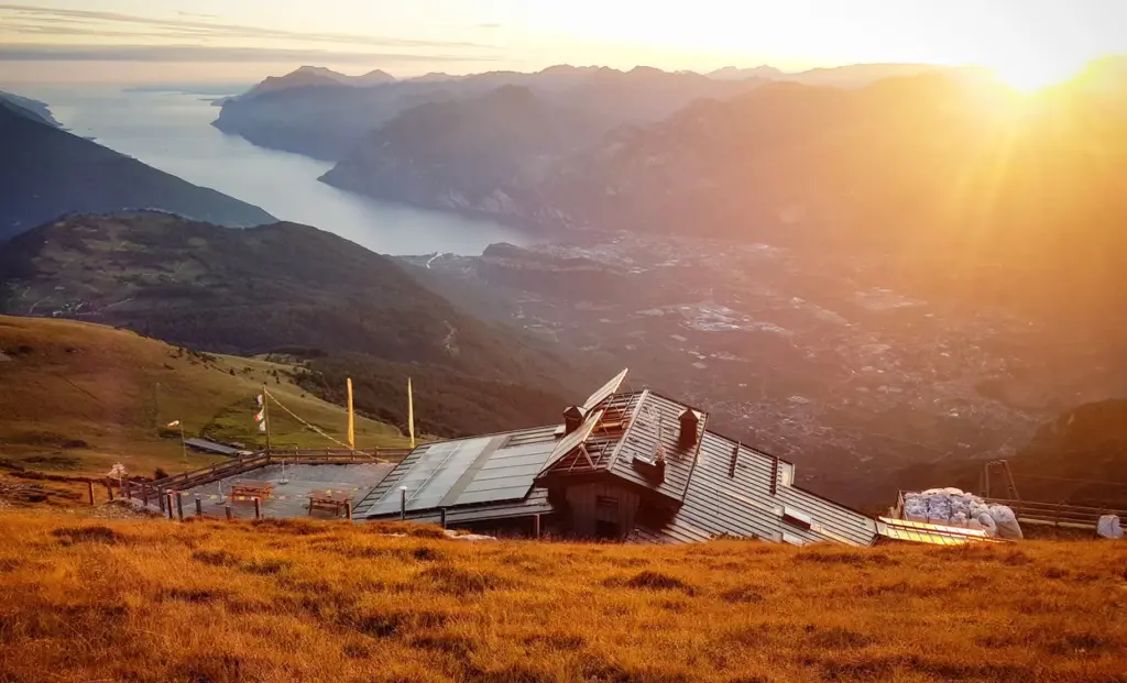 Rifugio Prospero Marchetti sul Monte Stivo con panorama sulle montagne del Garda Trentino.